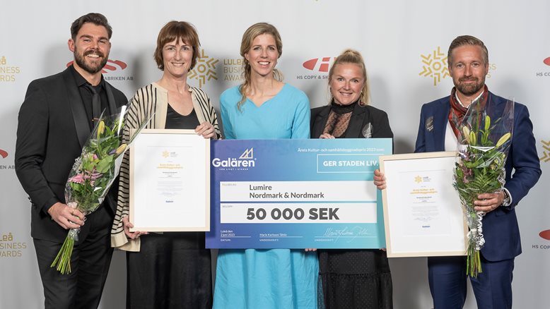 Bild på glada pristagare med en stor papperscheck