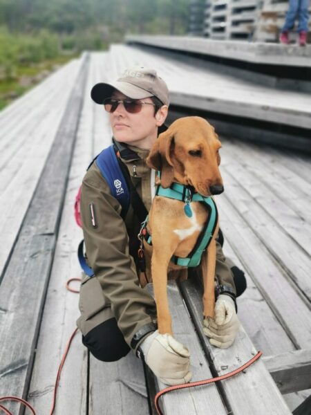 Bild på en människa med en hund på en brygga