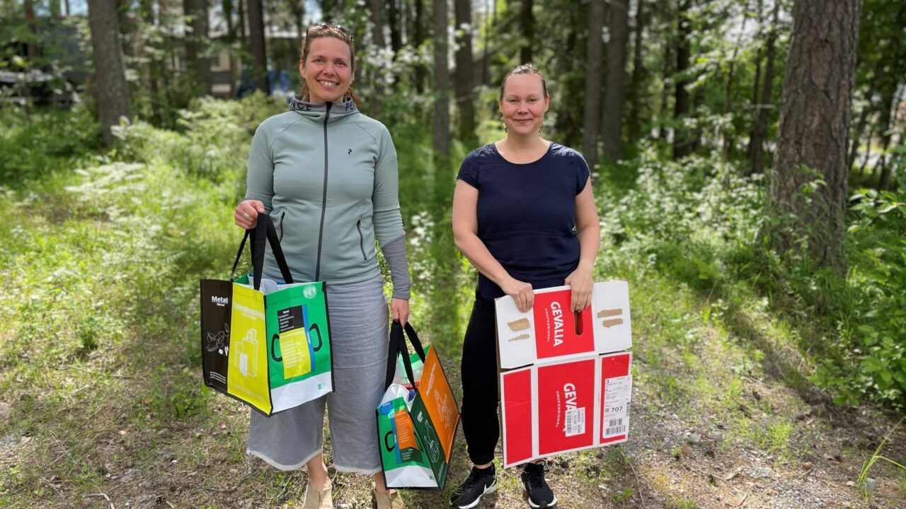 Människor i skog vid återvinningsstation