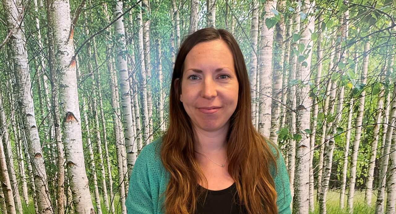Människa vid en vägg med tapet av träd