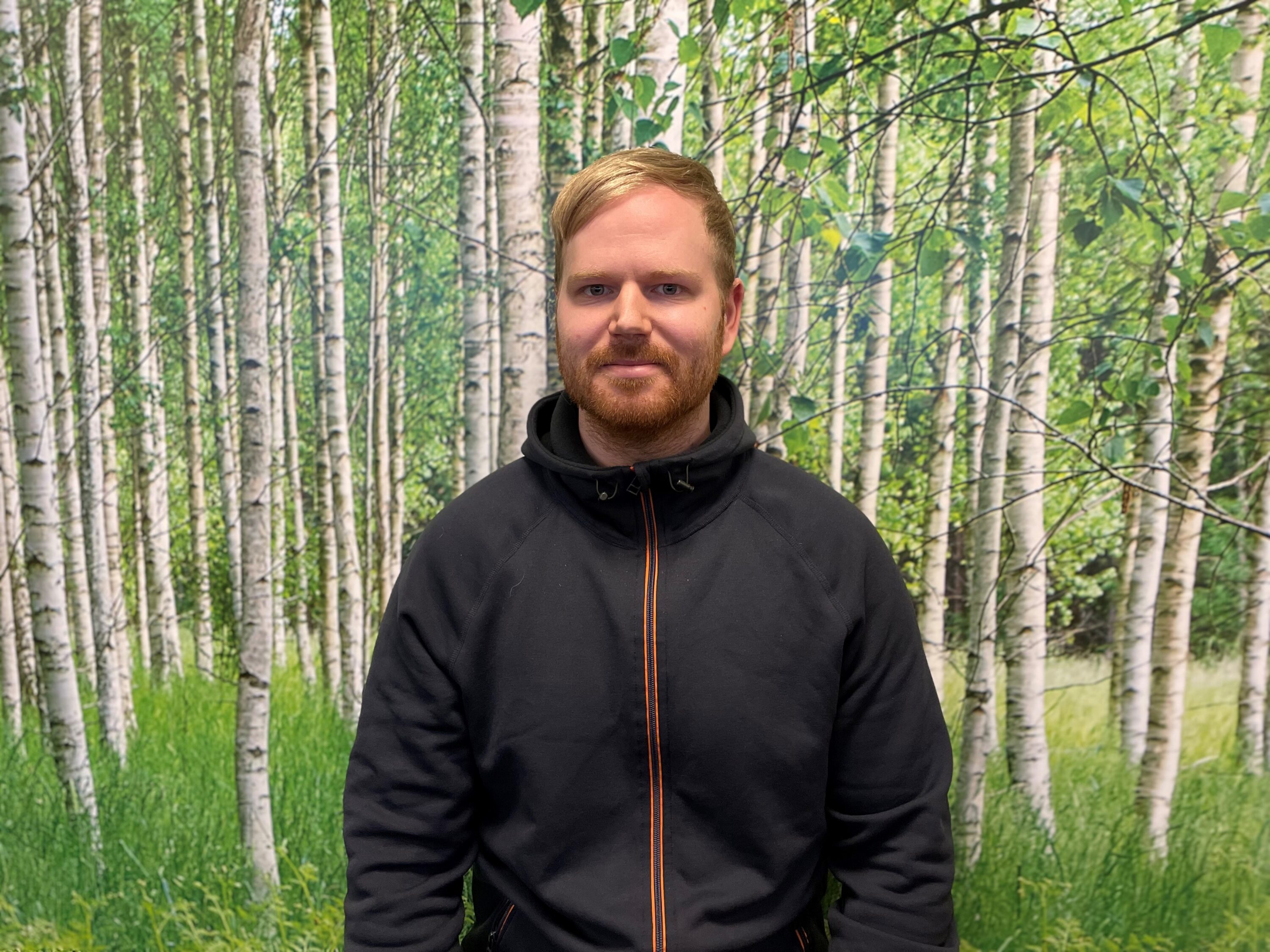 Människa inomhus vid tapet med träd