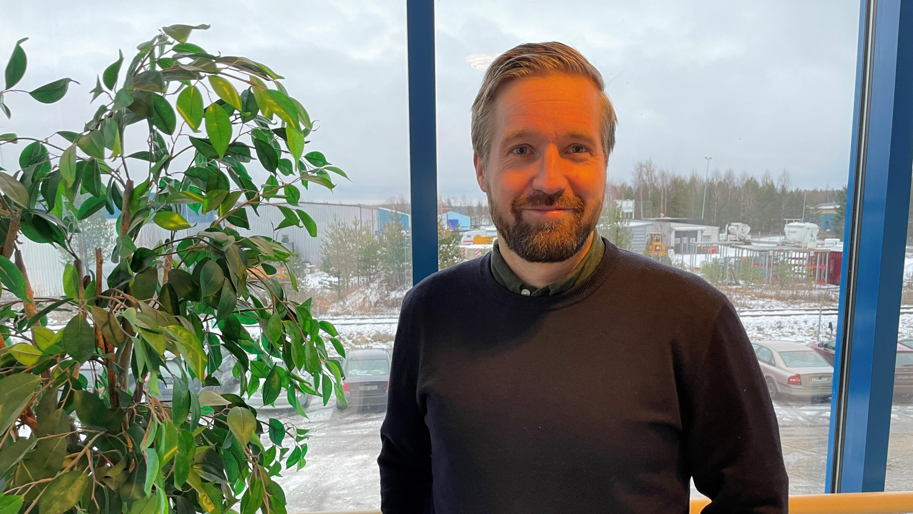 Människa vid glasparti och blomma
