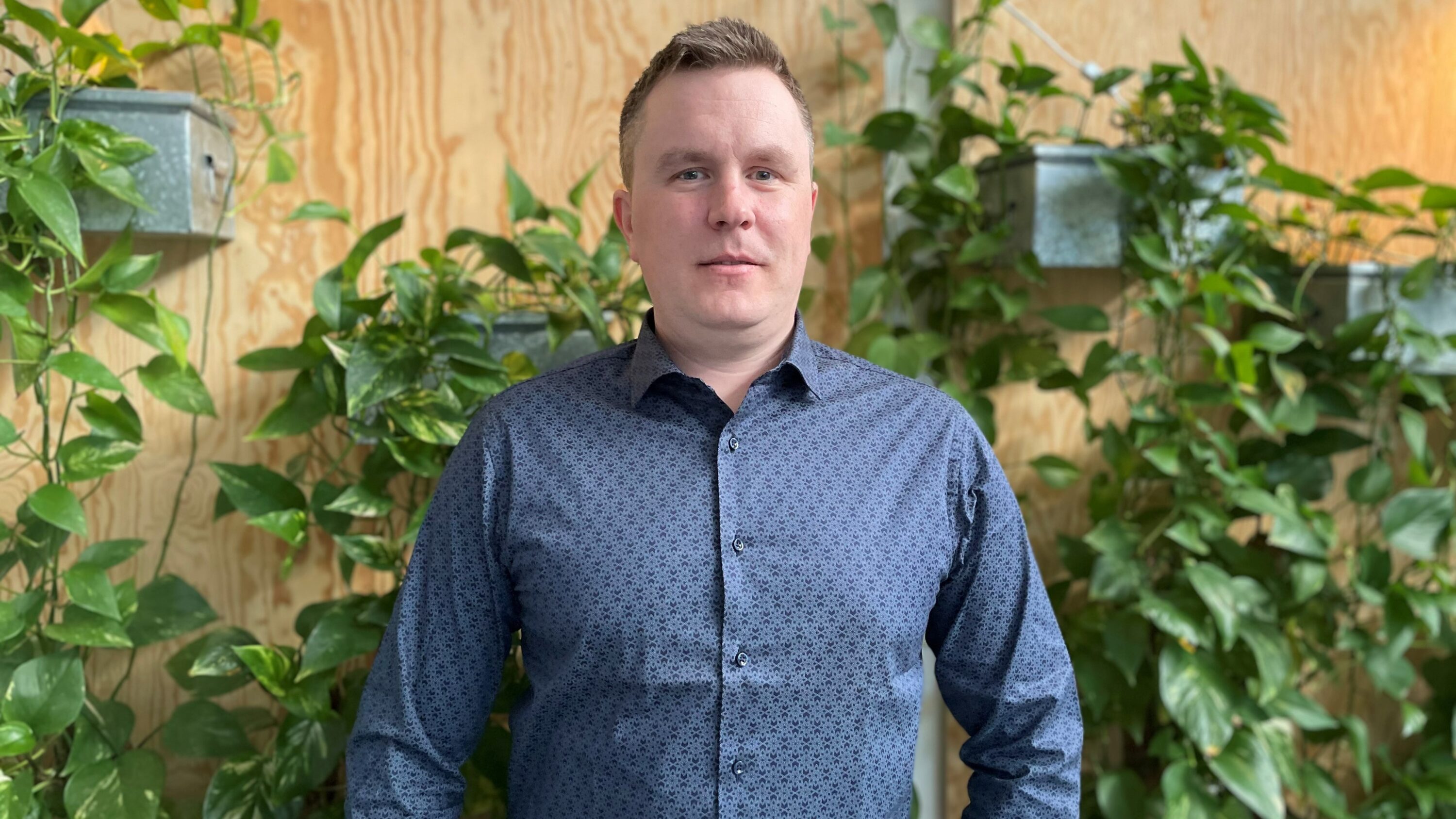 Människa vid vägg med gröna växter