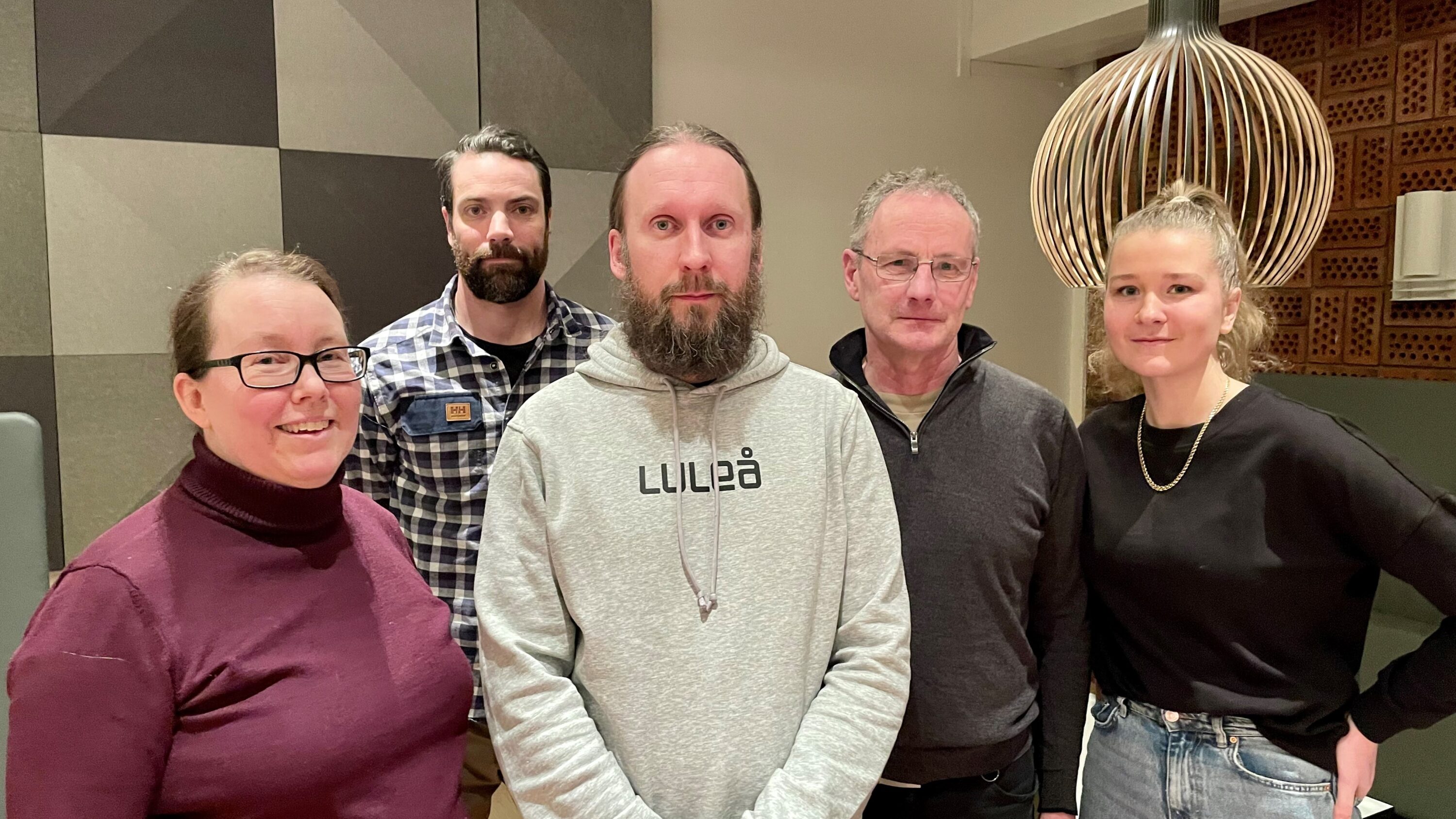 Fem människor inomhus samlade för presentation