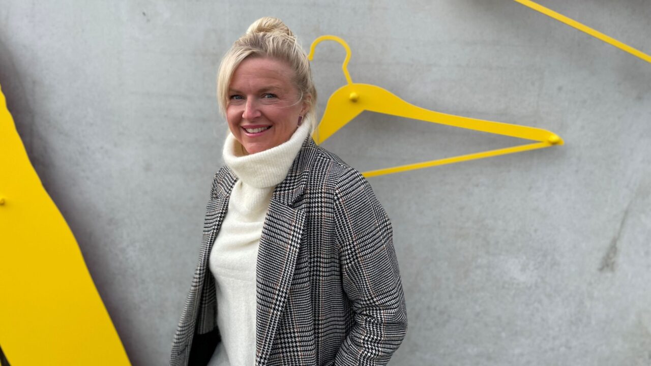 Människa vid cementvägg och gul galge