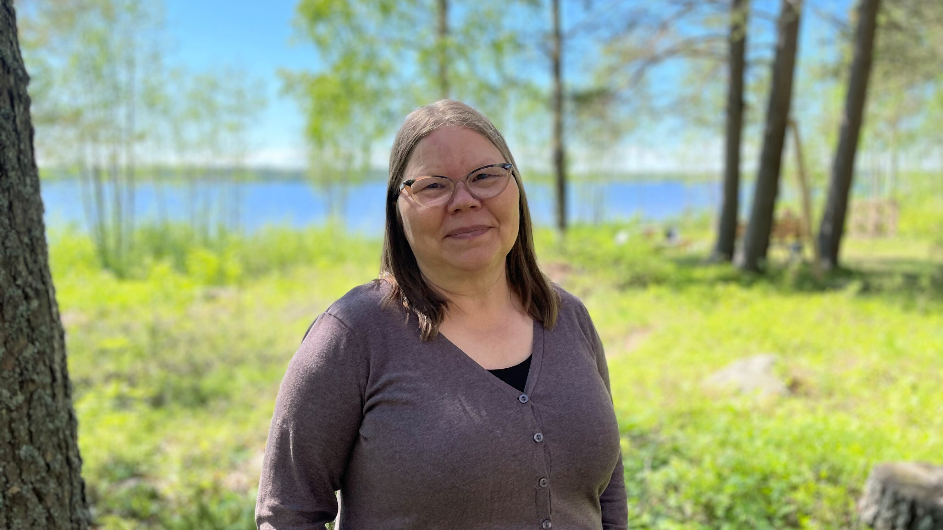 Bild på människa vid grönskande skog och vatten